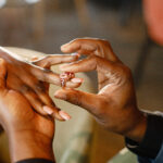 A hand putting a ring on another hand